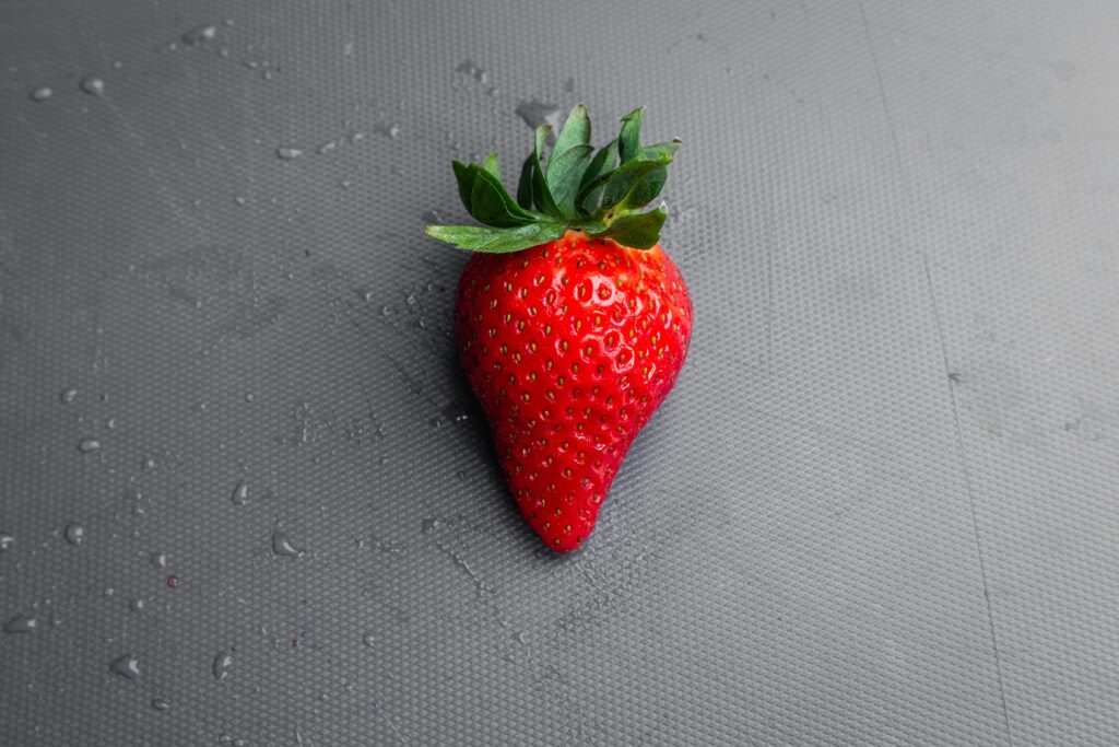 Strawberry laying flat on a grey table