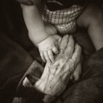 Image of a baby's hand holding an older person's hand